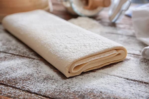 Raw flaky dough with flour on table — Stock Photo, Image