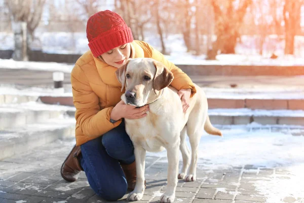 冬天的时候, 女人抱着可爱的狗在户外。宠物与主人之间的友谊 — 图库照片