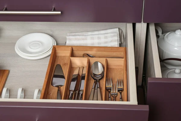 Различные столовые приборы в ящике на кухне — стоковое фото