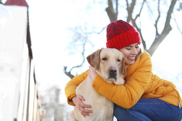 Mulher abraçando cão bonito ao ar livre no dia de inverno. Amizade entre animal de estimação e proprietário — Fotografia de Stock