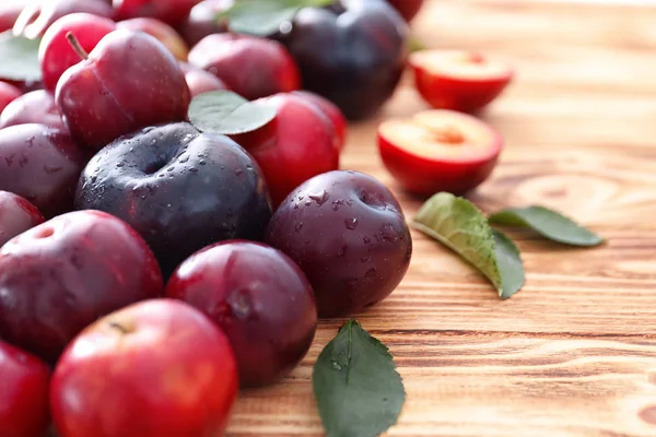 Ripe juicy plums on wooden table — Stock Photo, Image