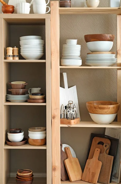 Skladovací stojan s keramické a dřevěné nádobí na barvu pozadí — Stock fotografie