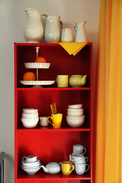 Roter Aufbewahrungsständer mit Keramikgeschirr drinnen — Stockfoto