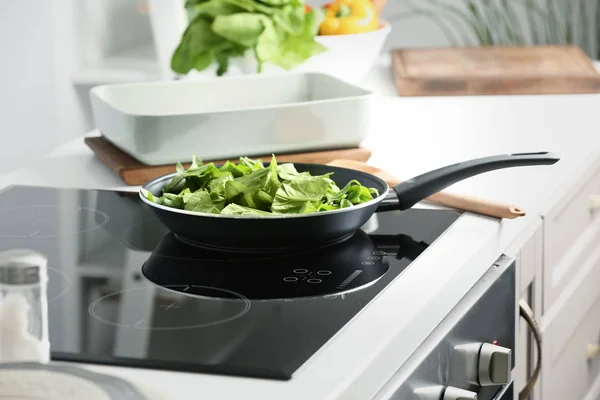 Frigideira com espinafre para lasanha em fogão elétrico na cozinha — Fotografia de Stock