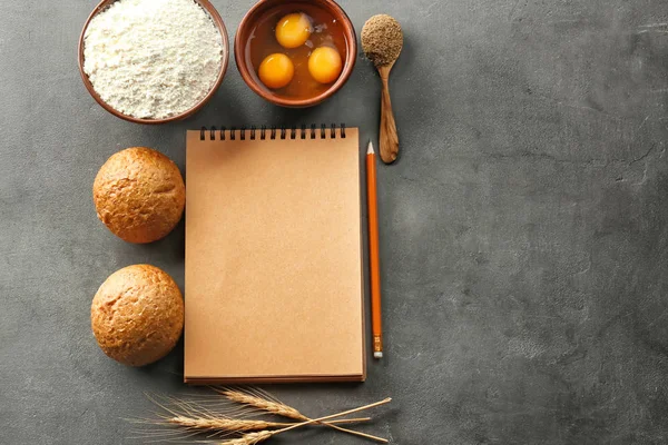 Notizbuch und Produkte zum Brotbacken auf grauem Hintergrund — Stockfoto