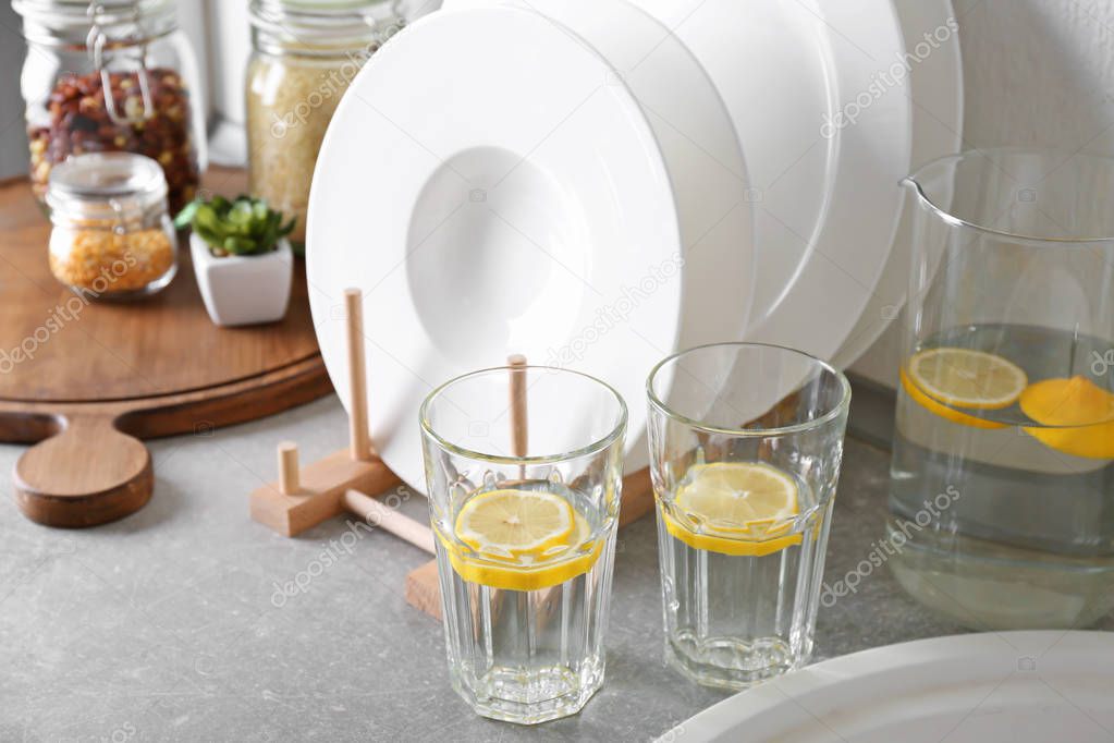 Set of white ceramic plates and fresh lemonade on kitchen counter