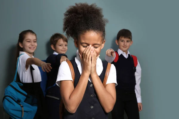 Children bullying African-American girl on color background — Stock Photo, Image
