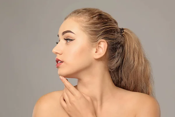 Young woman with beautiful eyebrows on grey background — Stock Photo, Image