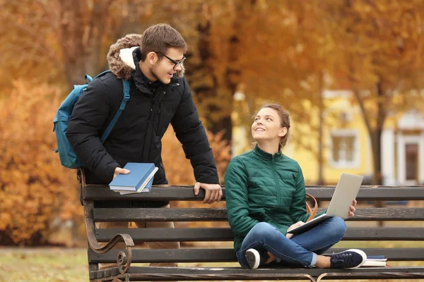 Подростки с ноутбуком учатся в парке — стоковое фото