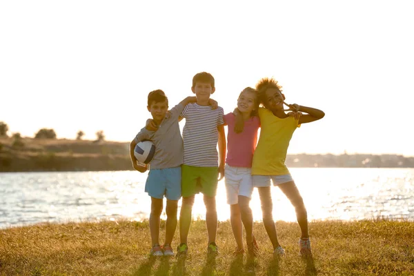 Schattige kinderen met bal op de rivier bank — Stockfoto