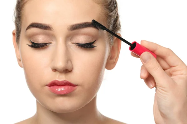 Young woman undergoing eyebrow correction procedure on white background, closeup — Stock Photo, Image