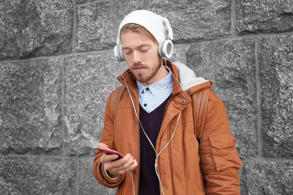 야외에서 음악을 듣고 하는 헤드폰으로 잘생긴 hipster의 초상화 — 스톡 사진