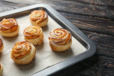 Puf böreği ahşap arka plan, closeup üzerinde elma gül ile fırın tepsisi