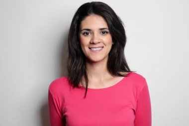 Işık arka plan üzerinde poz çekici genç kadın