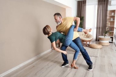 Mutlu olgun çift evde dans ediyor.