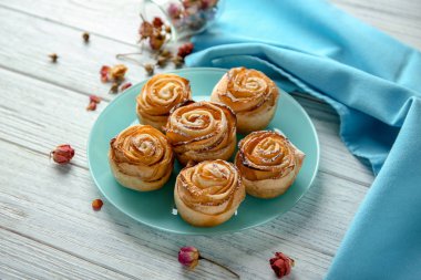 Puf böreği ahşap masa üzerinde elma gül ile plaka