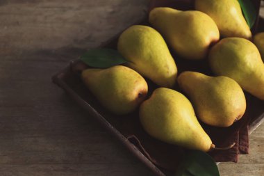 Tepsi ile ahşap masa üzerinde taze olgun armut