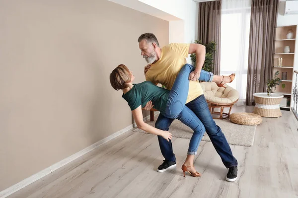 Mutlu olgun çift evde dans ediyor.