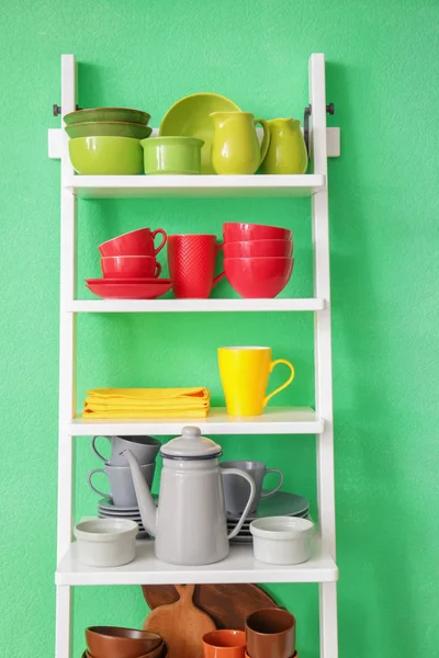 Белый Стеллаж Керамической Посудой Возле Цветной Стены — стоковое фото