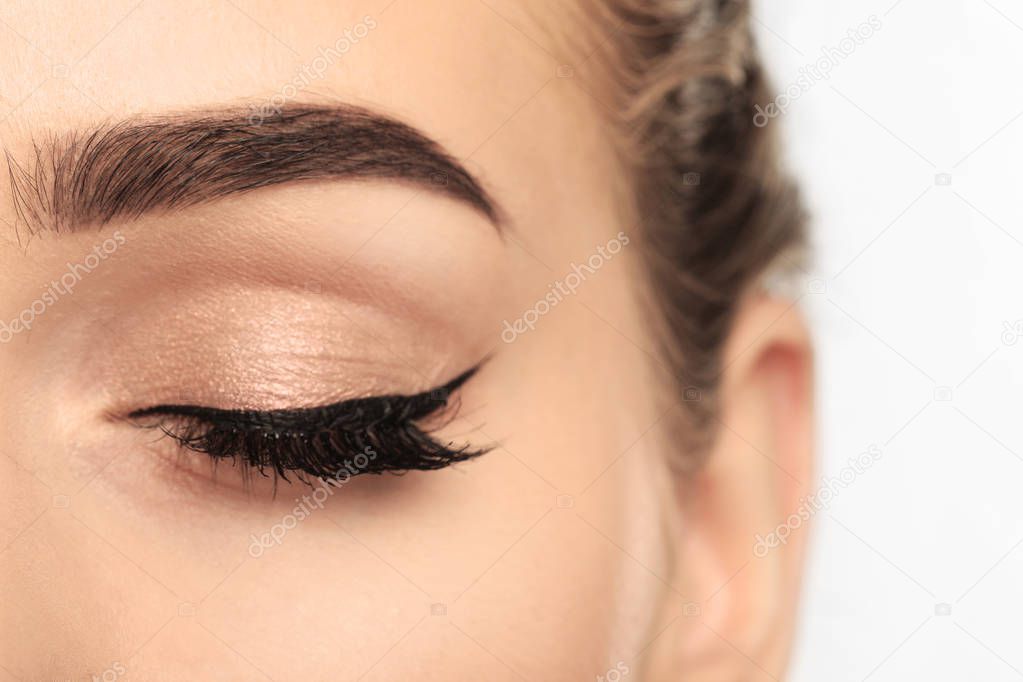 Eye of young woman with beautiful eyebrow after correction, closeup