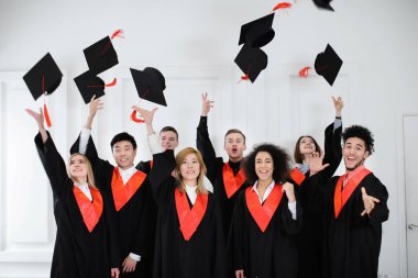 Mutlu öğrenciler lisans cüppeli mortarboards kapalı atma. Mezuniyet günü