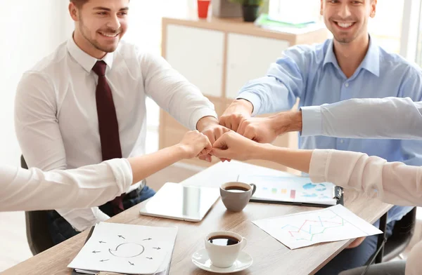 Los jóvenes en la oficina usan poner las manos juntas en el interior. Concepto de unidad — Foto de Stock