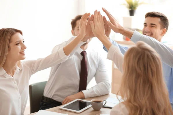 Los jóvenes en la oficina usan poner las manos juntas en el interior. Concepto de unidad — Foto de Stock