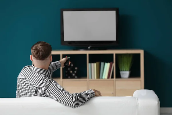 Ung man tittar på tv hemma — Stockfoto