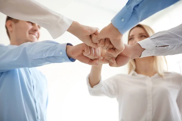 Los jóvenes en la oficina usan poner las manos juntas en el interior. Concepto de unidad — Foto de Stock