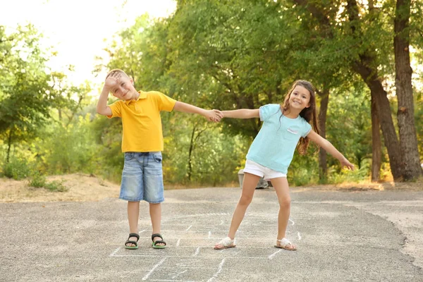 Petits enfants mignons jouant marelle, en plein air — Photo