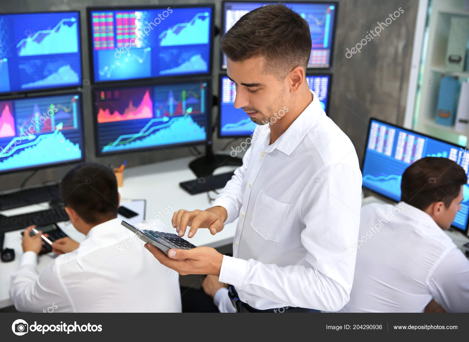 在办公室工作的男性股票交易员——图库图片© belchonock #204290936