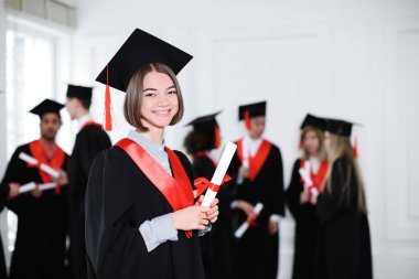 Mutlu Öğrenci Lisans elbise kapalı diploması ile içinde. Mezuniyet günü