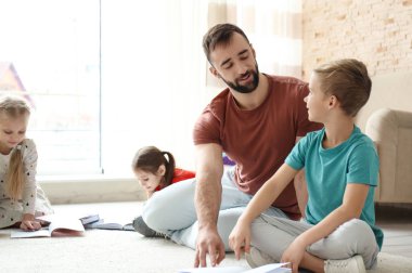 Erkek Öğretmen çocuk okulda sınıfta ödevlerini ile yardım