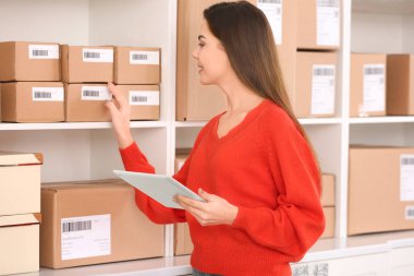 Parsel ev ofis istemcisinde sevkıyata hazırlanıyor tablet bilgisayar olan kadın