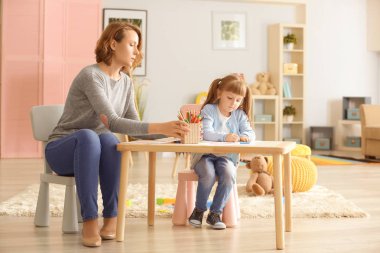 Sevimli küçük kız Sanat Terapisi sırasında kadın psikolog