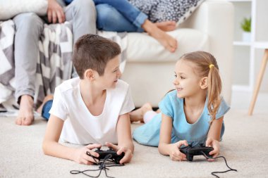 Sevimli çocuklar arka plan üzerinde dinleniyor ebeveynlerin iken video oyunları oynarken