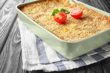 Ahşap masa üzerinde lezzetli ıspanaklı lazanya ile fırın tepsisi