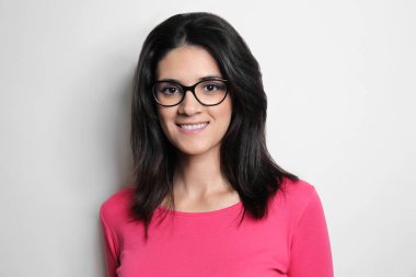 Işık arka plan üzerinde poz çekici genç kadın