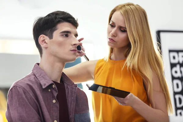 专业化妆艺术家与年轻模特在沙龙工作 — 图库照片