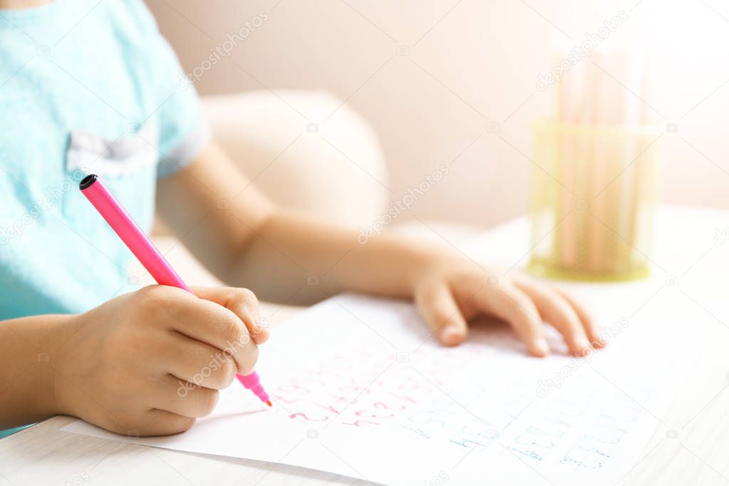 close up of little girl doing homework at table