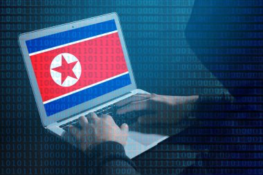 Hacker laptop ile masada çalışıyor. Kuzey Kore bayrağı üstünde perde. Hükümete karşı siber saldırı tehdidi 