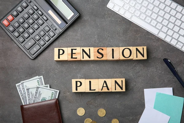 Cubes with text PENSION PLAN, money and stationery on grey background