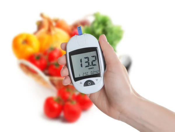 Frau mit digitalem Glukometer und gesunder Ernährung auf weißem Hintergrund — Stockfoto