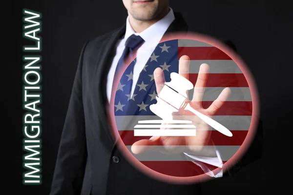 テキスト移民法 仮想画面暗い背景にアメリカの国旗と裁判官の小槌ボタンを押す男 — ストック写真