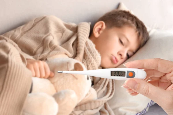 Mujer Sosteniendo Termómetro Con Alta Temperatura Niño Enfermo Acostado Sofá — Foto de Stock