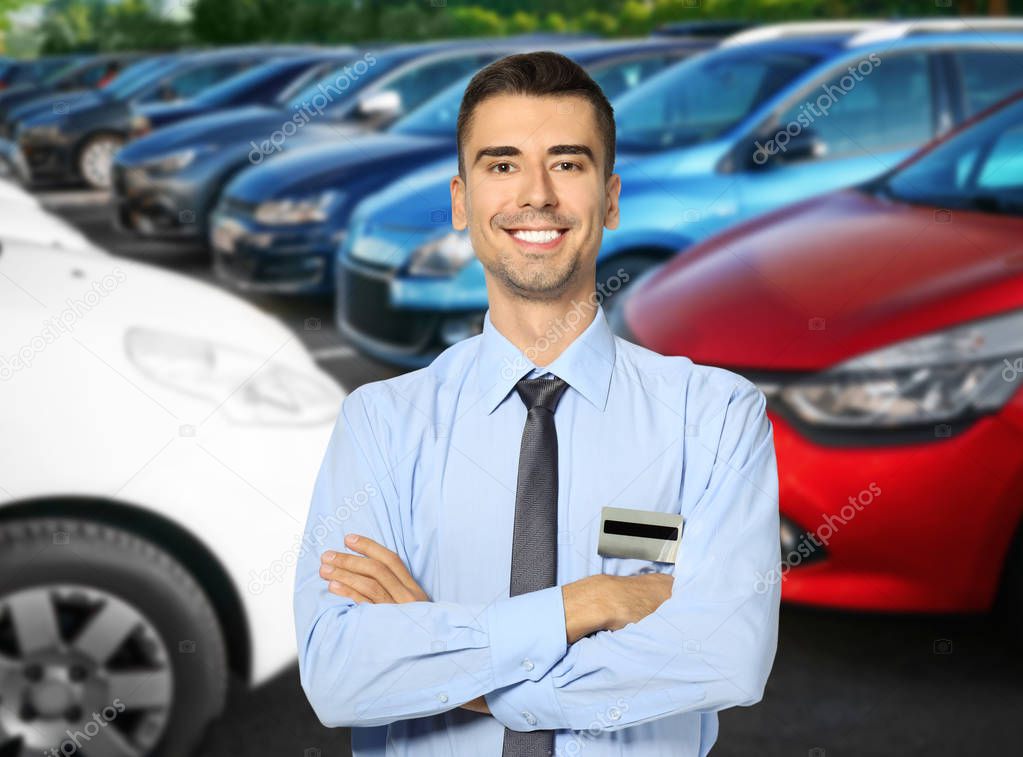 Portrait of salesman near cars outdoors