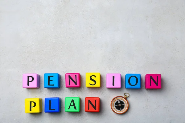 Colorful cubes with text PENSION PLAN and compass on light background