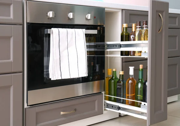 Bottles of oil and wine near oven in kitchen