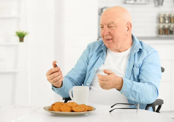 Senior Mannen Äter Frukost Medan Spelar Domino Vårdhem — Stockfoto