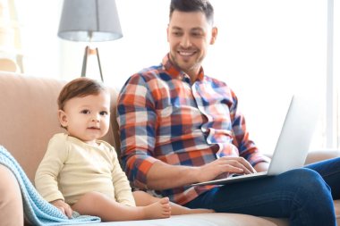 Yakışıklı baba ve oğlu evde koltukta oturan